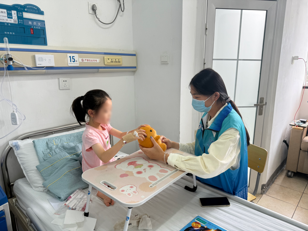 社工志愿者在儿科陪小朋友互动做游戏。河北省医科大学第一医院供图