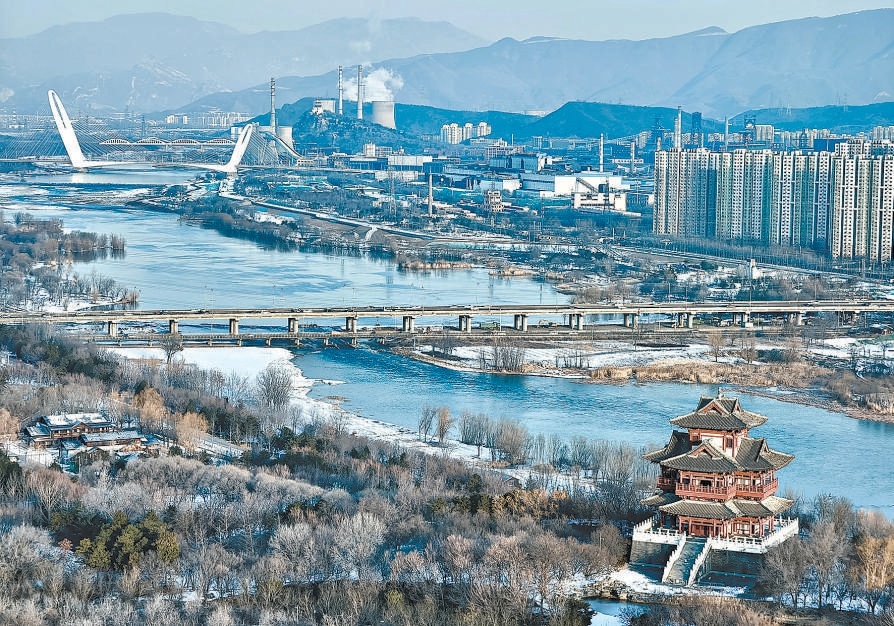 2025年12月15日早晨，永定河两岸白雪皑皑，河水奔涌不息。